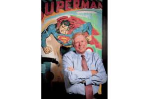 Jim Malone standing in front of a painting of Superman.